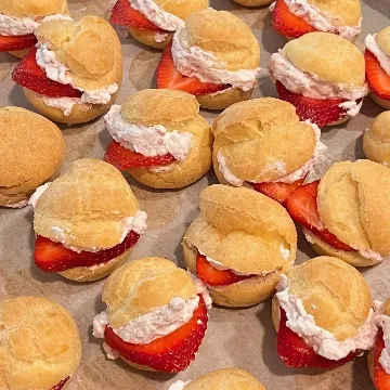 Strawberry cream puffs on a baking tray